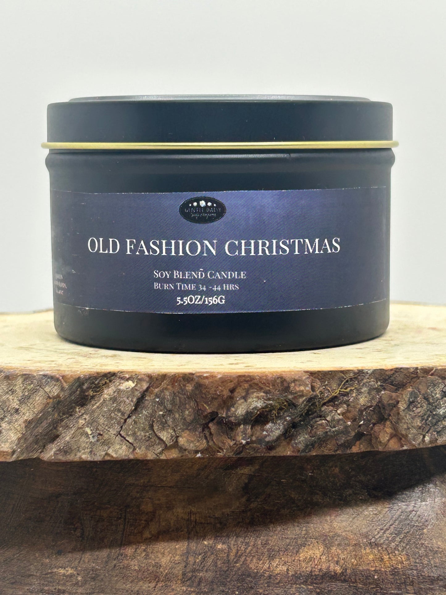 Black candle tin labeled 'Old Fashion Christmas' on a wooden surface.
