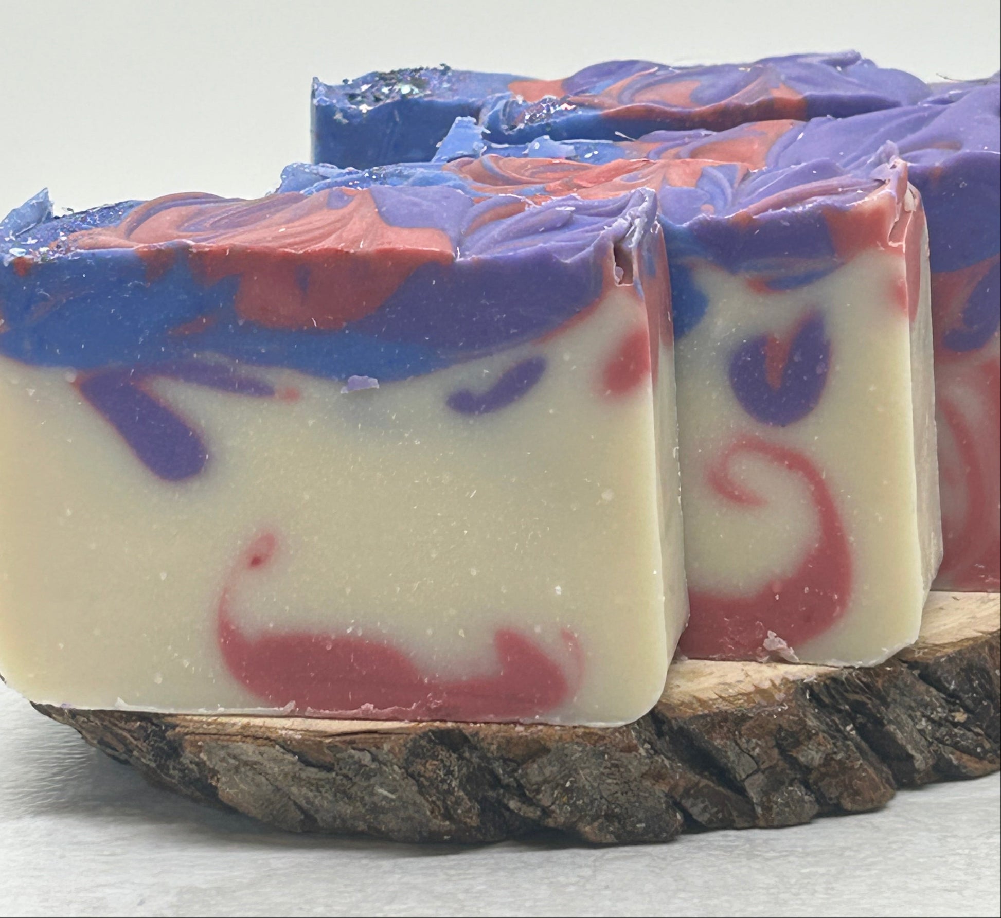 Decorative soap bars with purple and red swirls on a white background