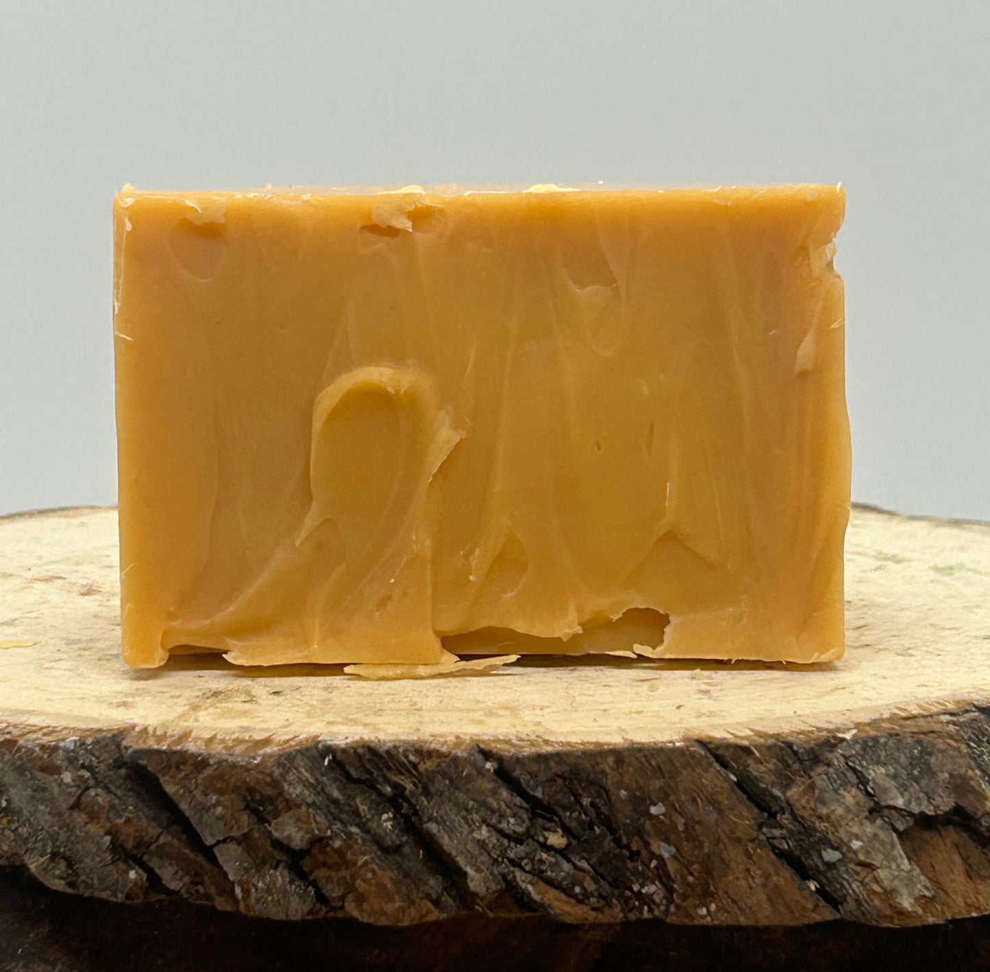 Grapefruit goat milk soap on a wood slab