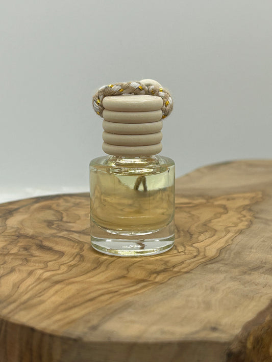Small glass bottle with a textured cork stopper on a wooden surface car diffuser